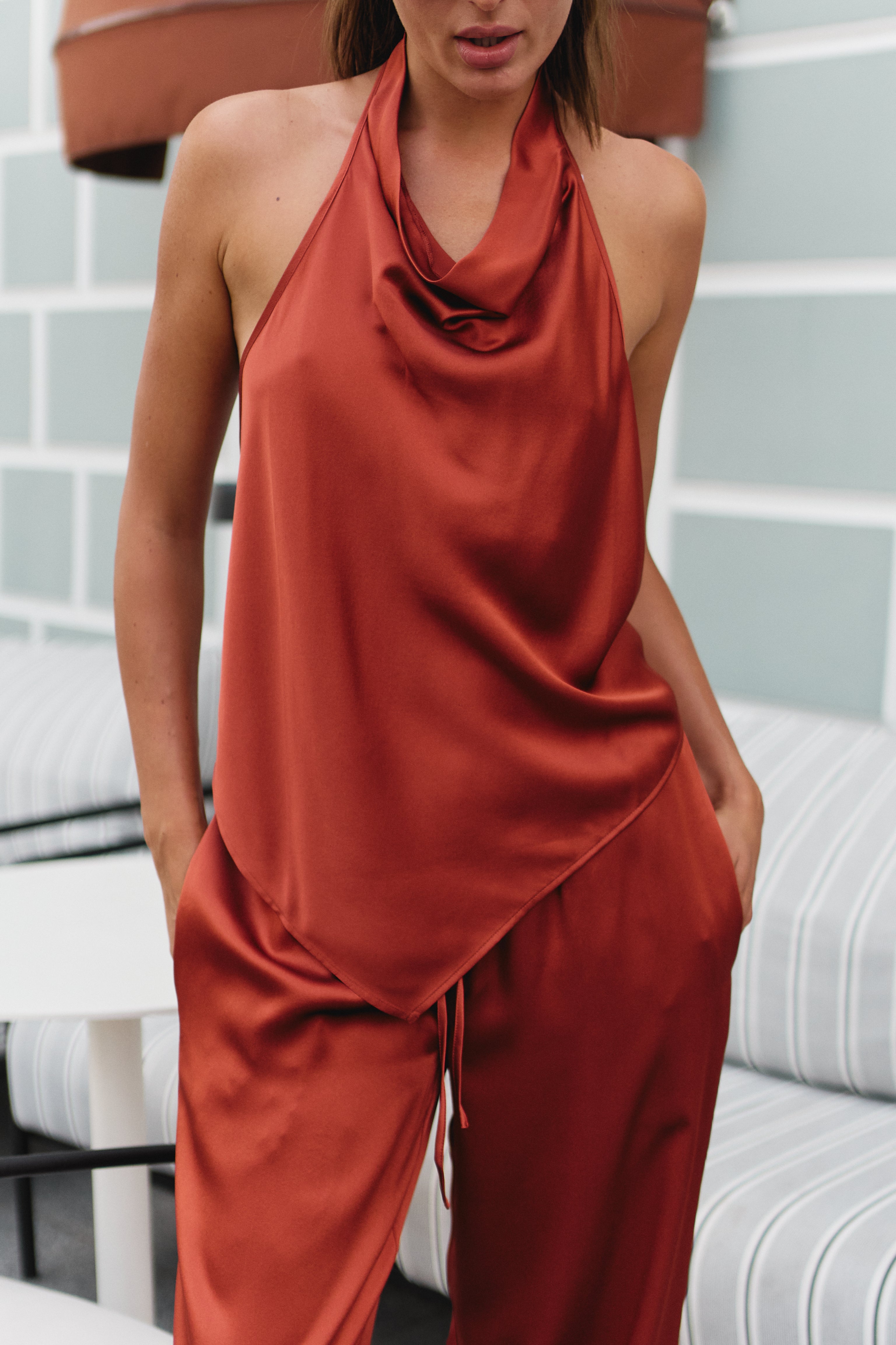 Silk halter top Nokaya in terractta. Street style with trousers.
