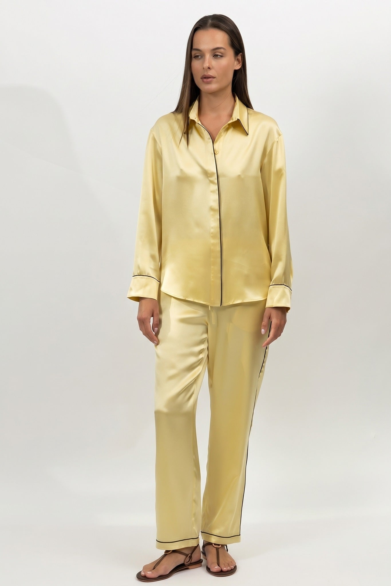 A woman in silk pyjamas set in yellow on a white background by Nokaya