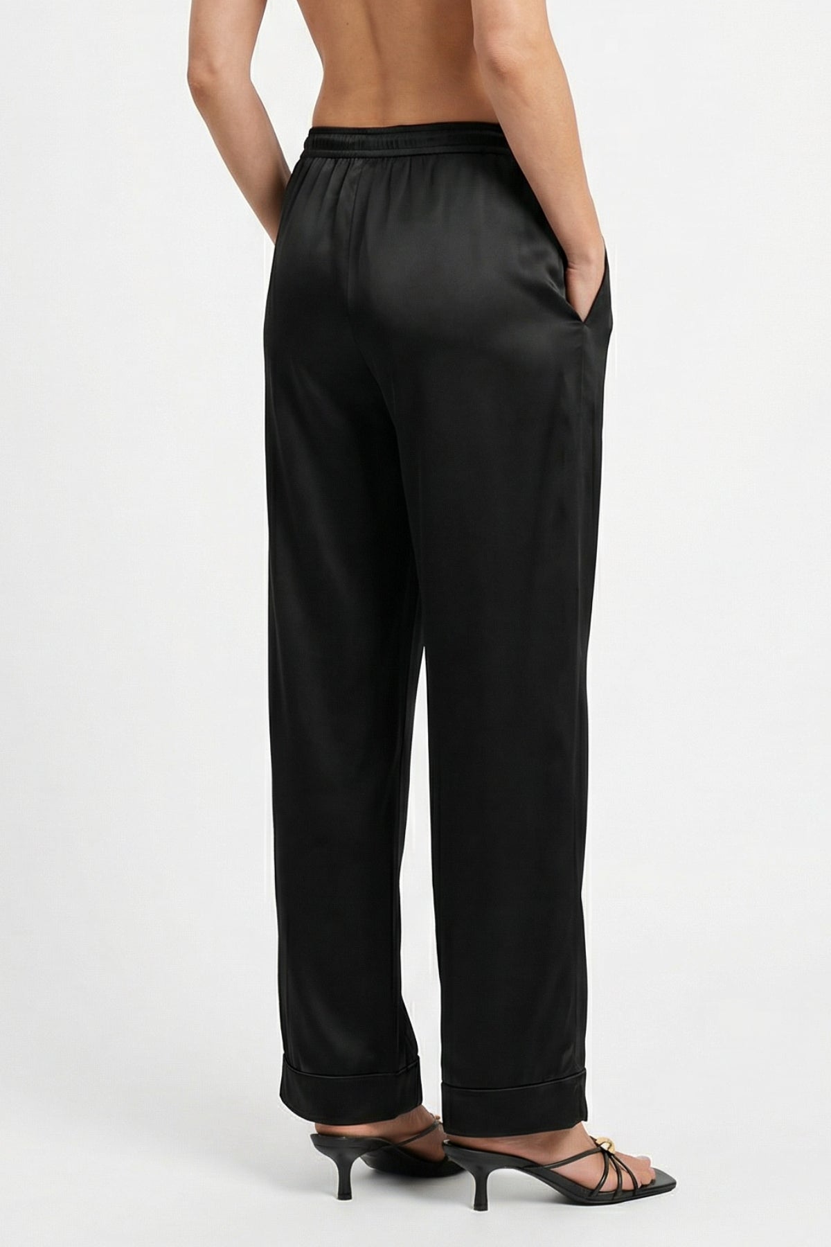 Silk black pants, Nokaya. Back view. Worn by a person on a white background