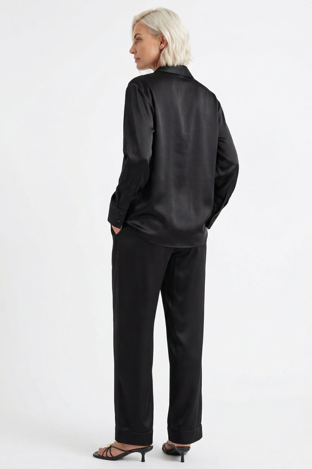 Person wearing a black silk shirt and pants Nokaya on a white background