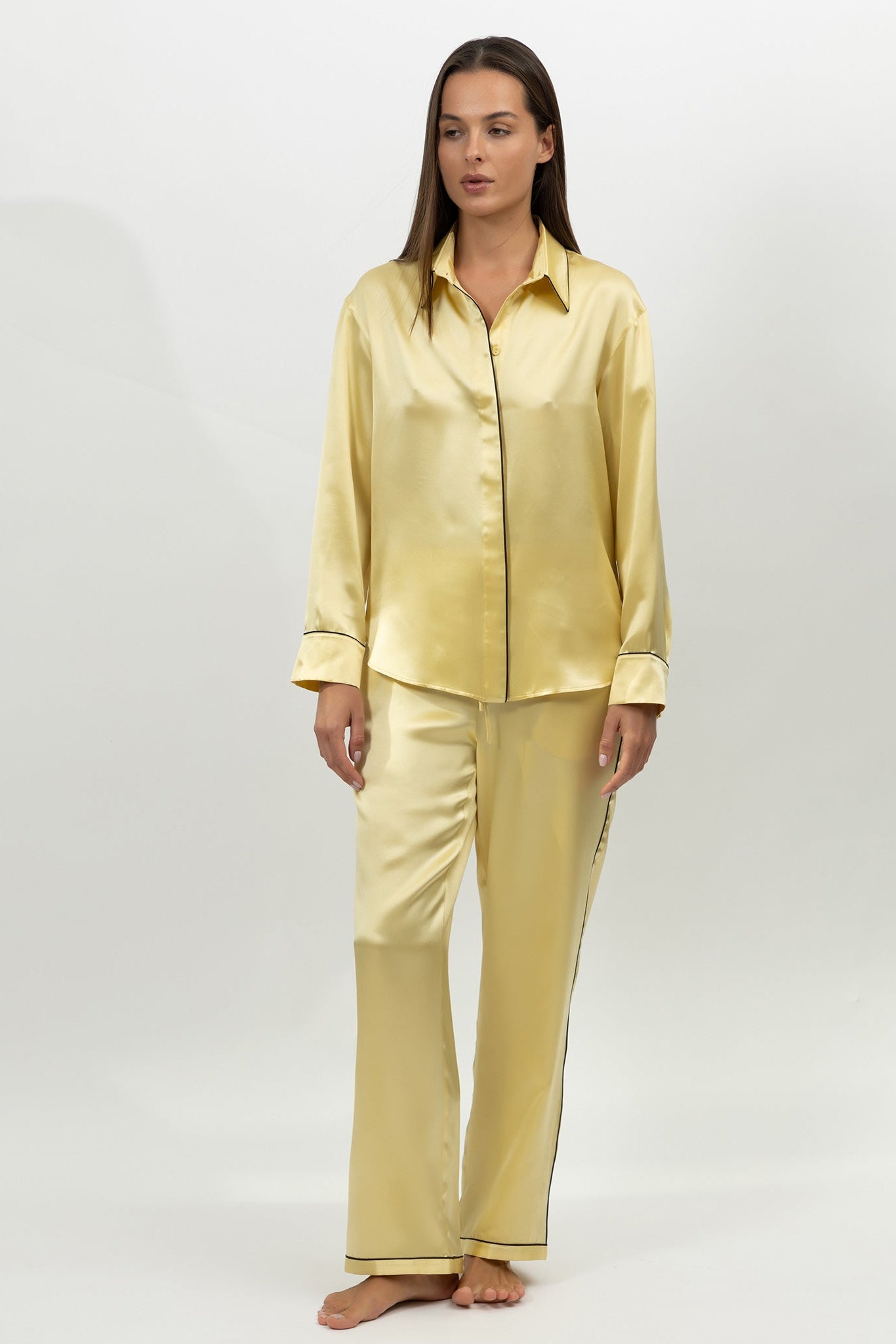 A woman in silk pyjamas set in yellow on a white background by Nokaya