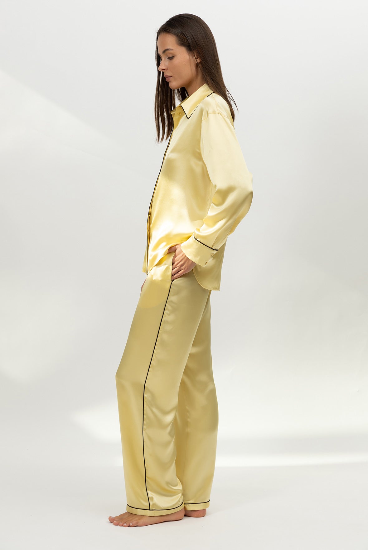 Yellow silk satin pyjama set on a white background. Nokaya. Side front.