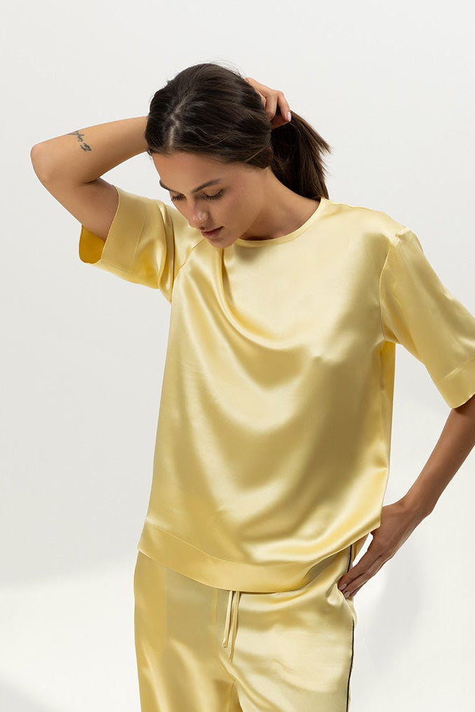 Woman wearing a yellow pajama set on a white background