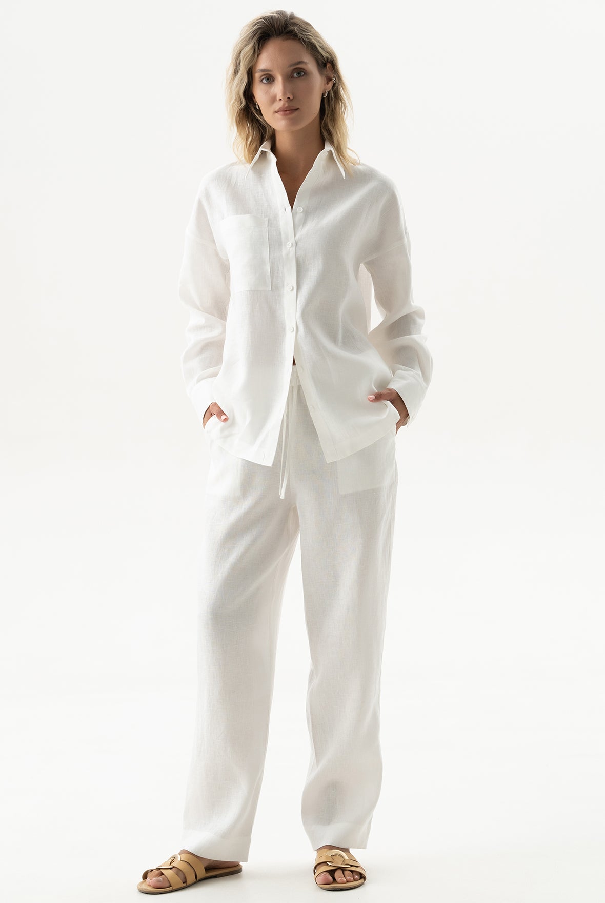 A woman wearing a white linen outfit Nokaya on a white background