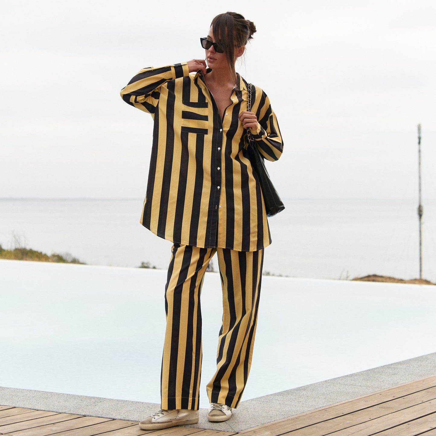 A person wearing a black and yellow striped Nokaya's outfit by a poolside.