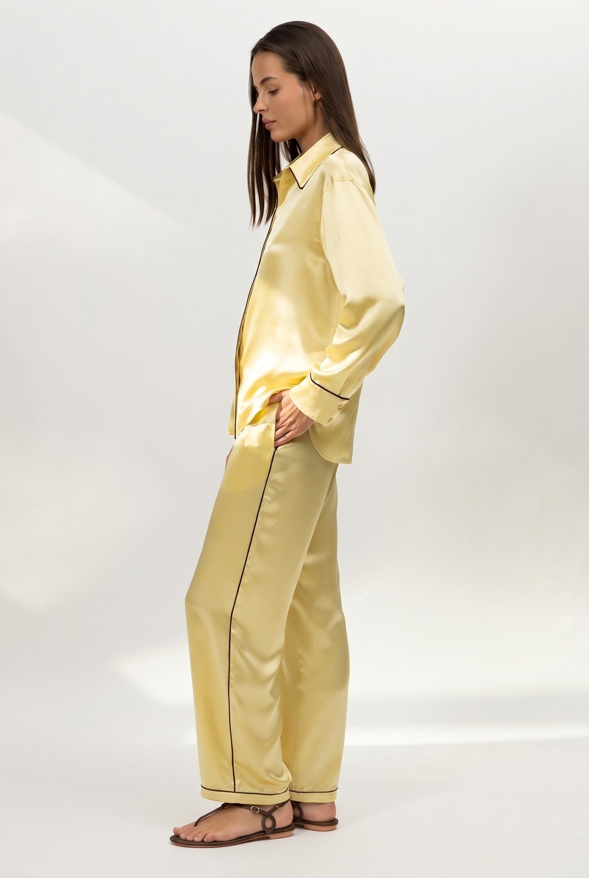 Yellow silk satin pyjama set on a white background. Nokaya. Side front.