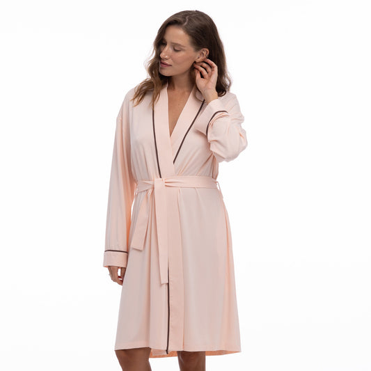 Woman wearing a light pink robe on a white background
