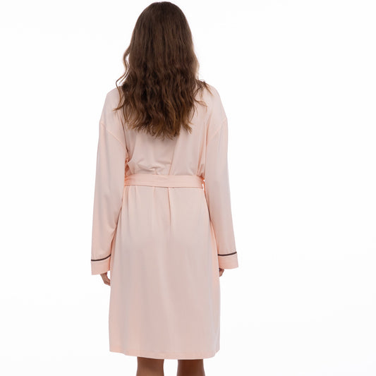 Woman wearing a light pink mamboo robe Nokaya  on a white background