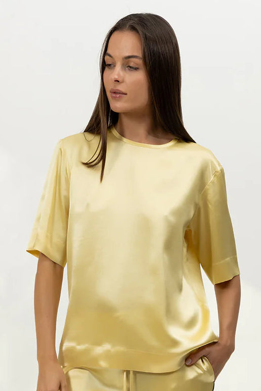 Silk t-shirt in yellow  on a Woman against a white background
