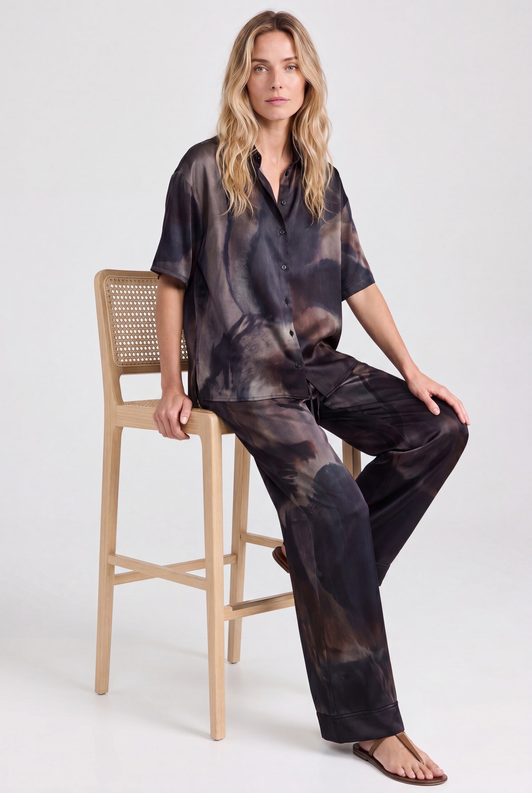 NOKAYA Mirage silk co-ord, seated on oak cane stool