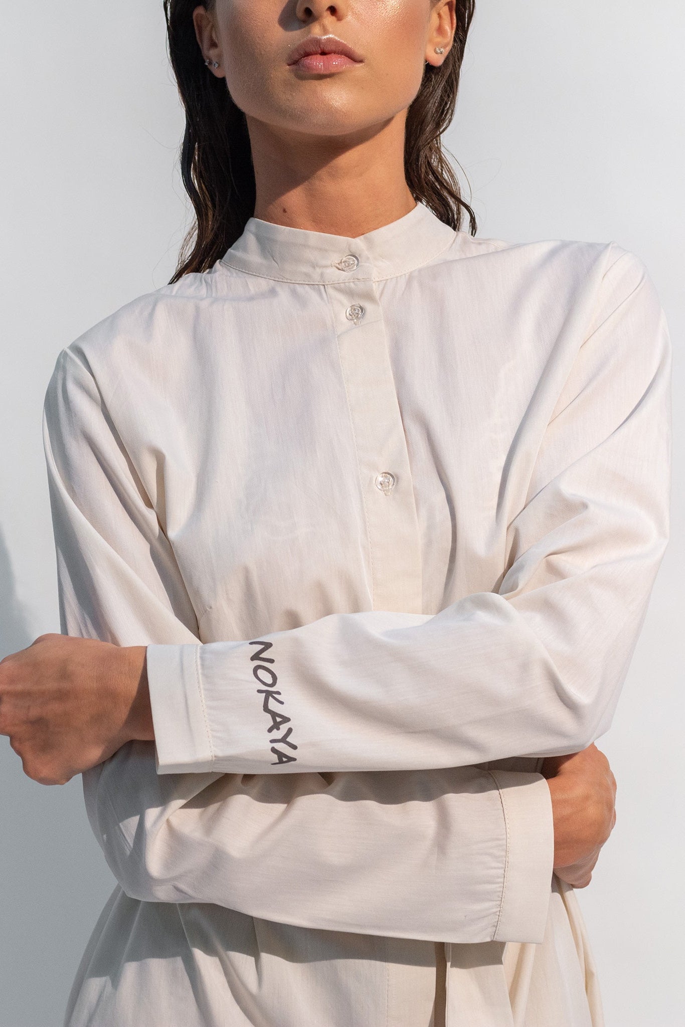 The Inner Matters cotton dress features a stylish, asymmetrical cut with a thin belt accentuating a silhouette.