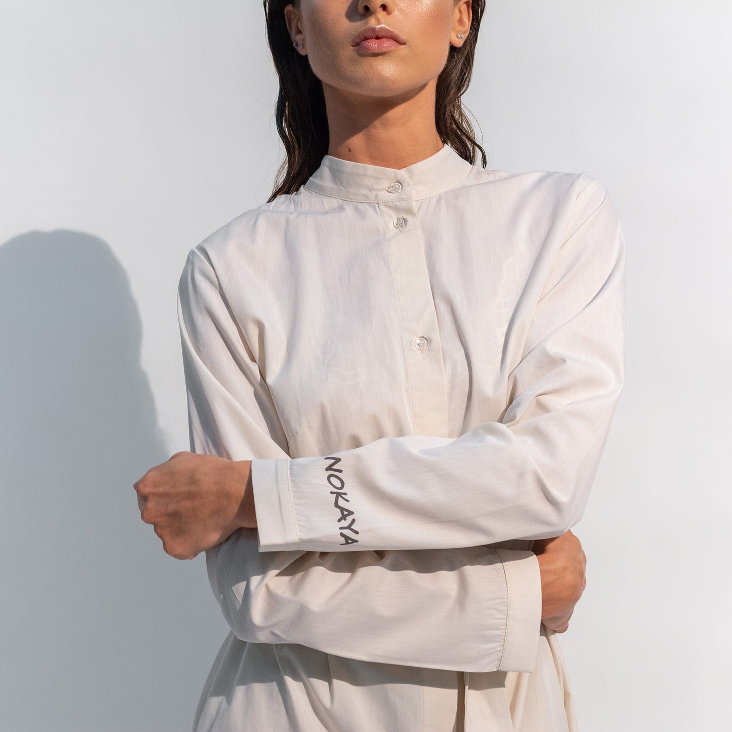 The Inner Matters cotton dress features a stylish, asymmetrical cut with a thin belt accentuating a silhouette.