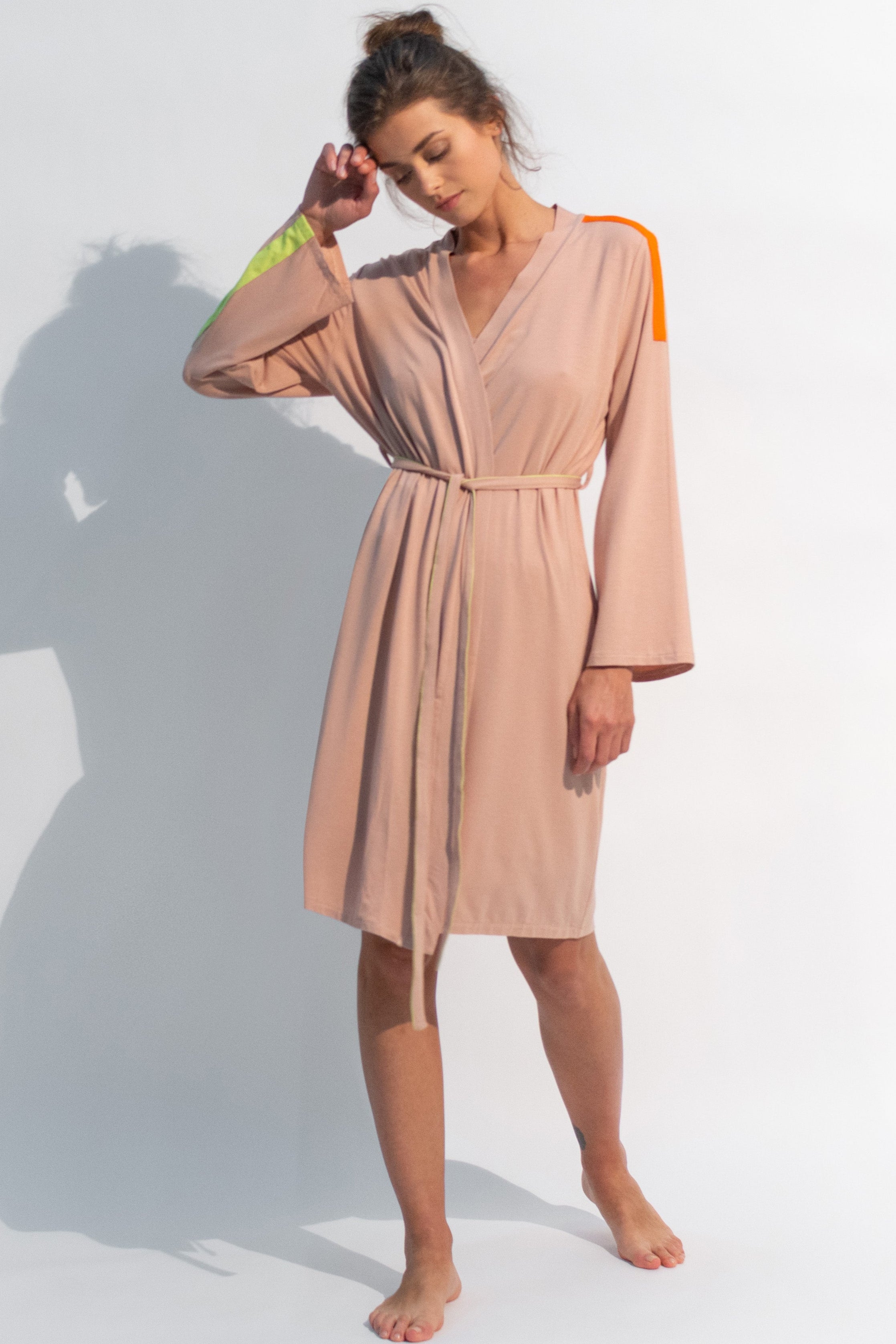 The V-neck style is detailed with contrasting bright piped trim and a self-tie belt. 